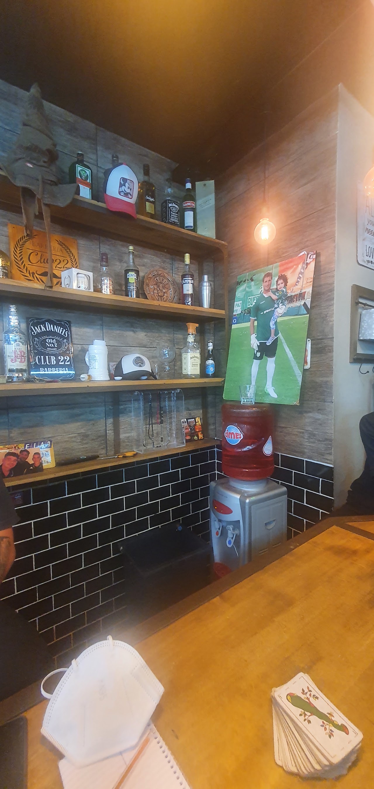Estantería de Barberia Club 22 con productos y ambientación de bar